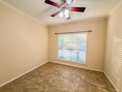 an empty room with windows and fan