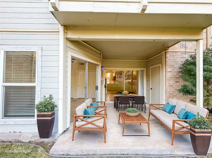 a view of yellow house with large windows and potted plants
