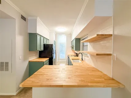 a large white kitchen with wooden floor