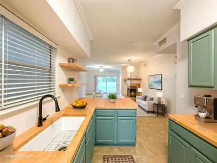 a large kitchen with a sink and living room view