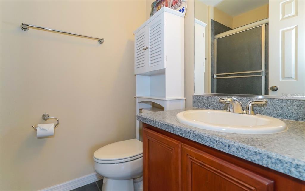 7339 Black Walnut Way Lakewood Ranch, FL 34202 - Photo 16 of 27 a bathroom with a granite countertop toilet sink and mirror
