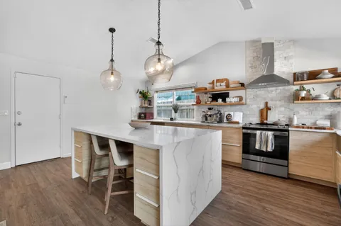 a kitchen with kitchen island stainless steel appliances a table and chairs