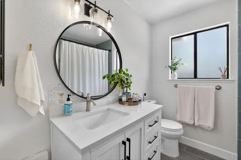 a bathroom with a sink mirror and toilet