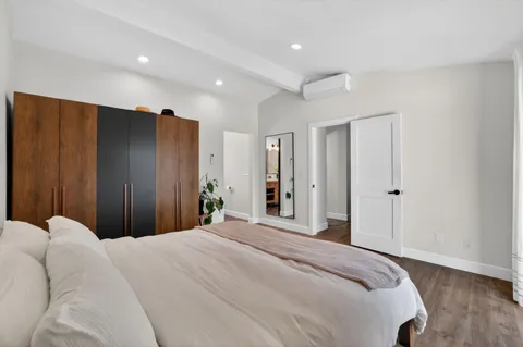 a bedroom with a large bed and wooden floor