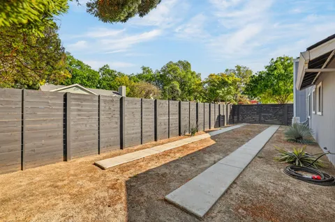 a view of a backyard with wooden fence