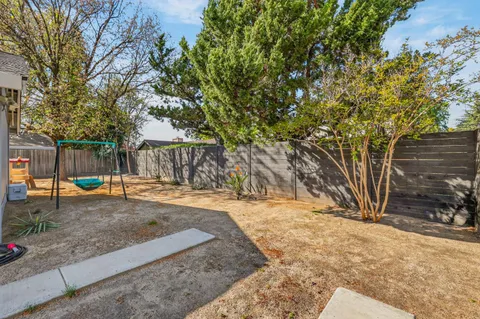 a view of a backyard with large trees and a barn