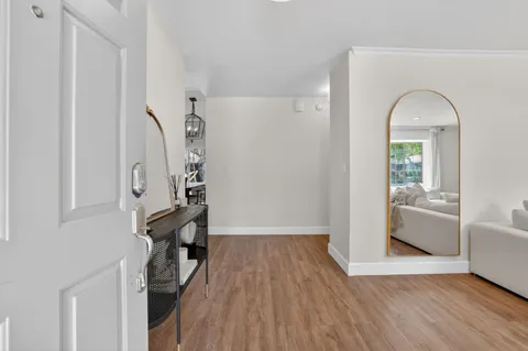 a view of empty room with wooden floor and fan