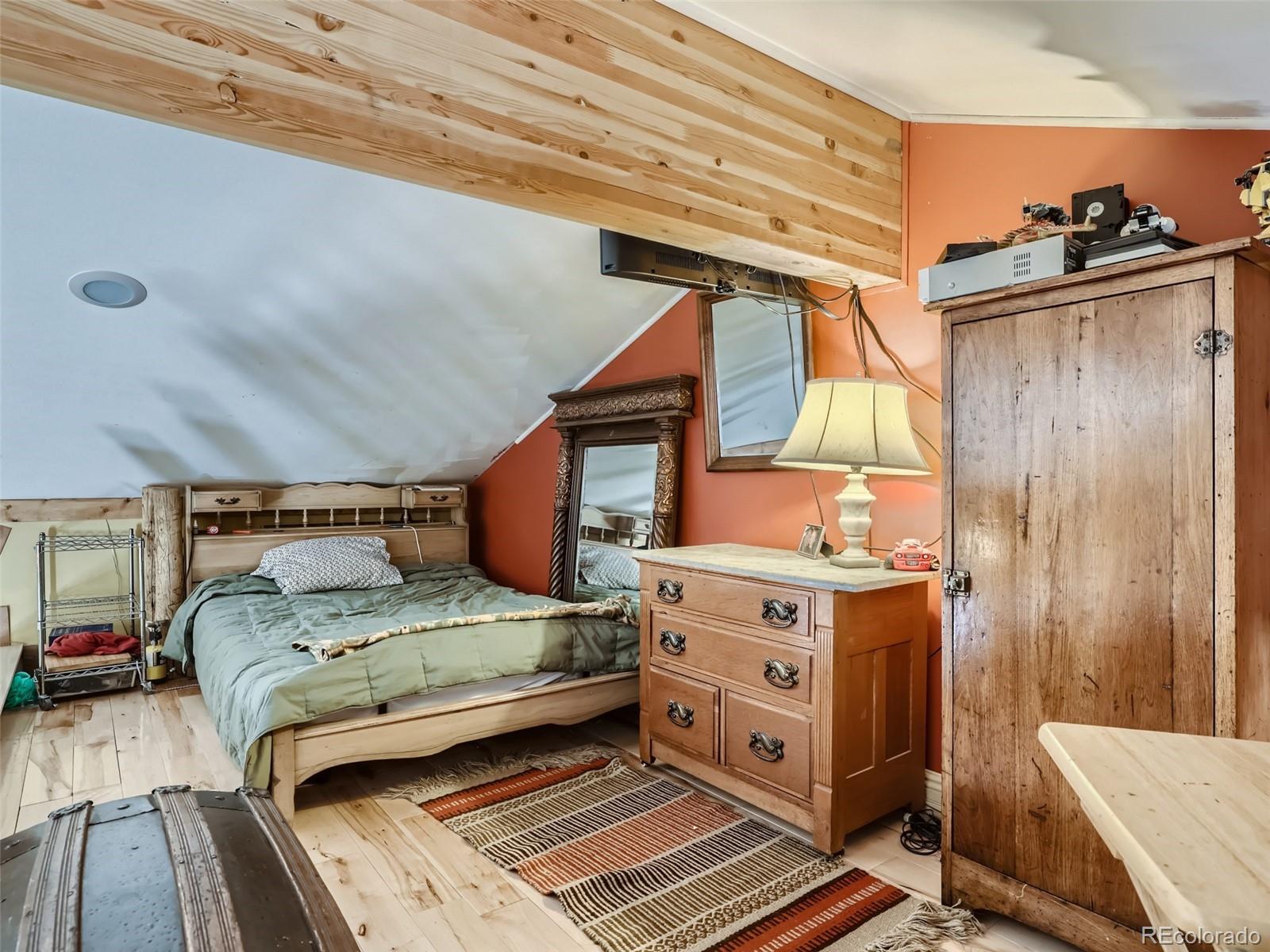 33657 Valley View Drive Evergreen, CO 80439 - Photo 10 of 13 a bedroom with a bed and wooden floor