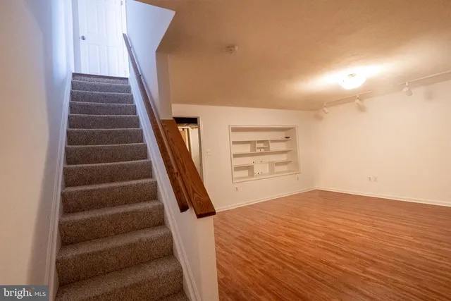 a view of empty room with wooden floor