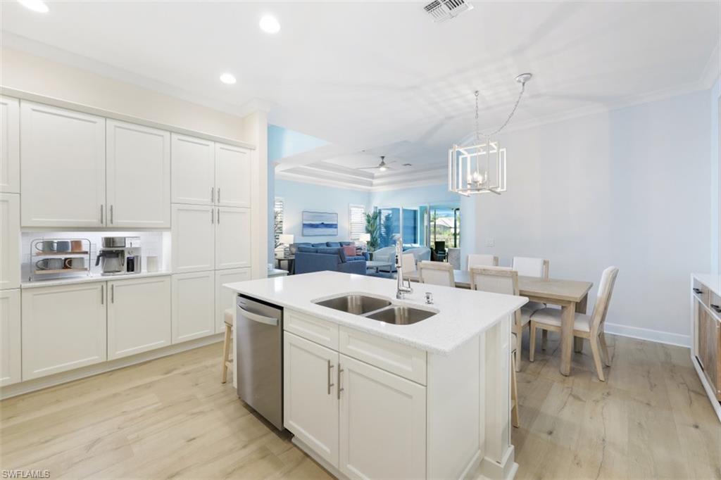 6295 Arriba Avenue Naples, FL 34113 - Photo 12 of 34 a kitchen with a sink and white cabinets