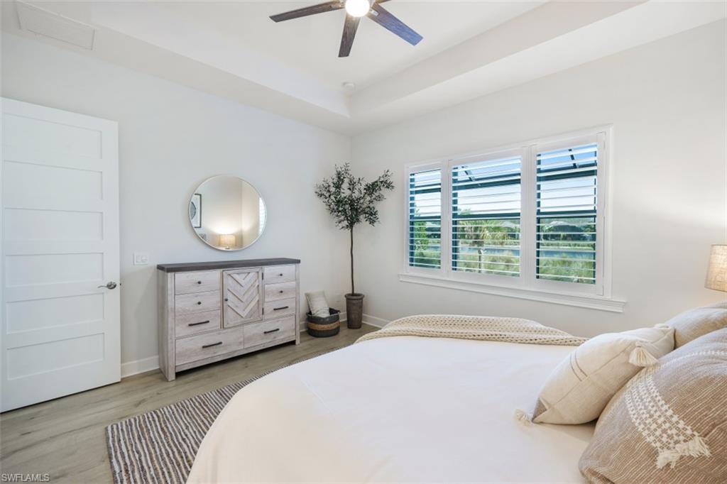 6295 Arriba Avenue Naples, FL 34113 - Photo 15 of 34 a spacious bedroom with a bed and a chandelier