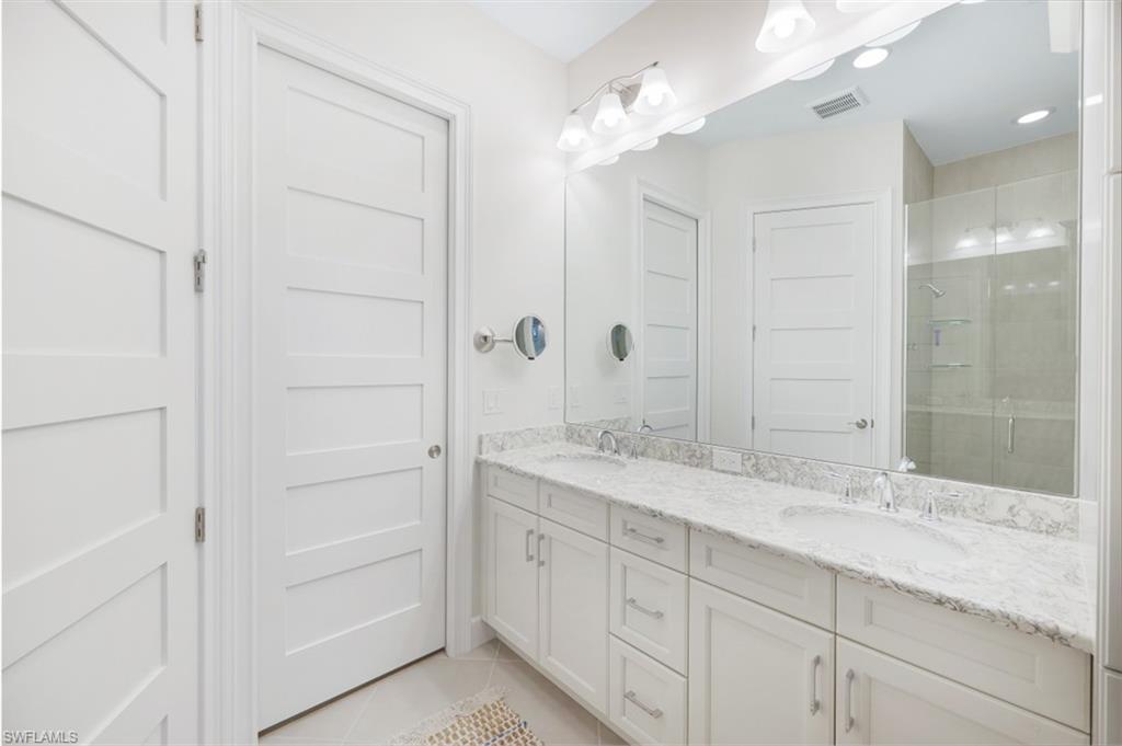 6295 Arriba Avenue Naples, FL 34113 - Photo 16 of 34 a bathroom with a granite countertop sink mirror and
