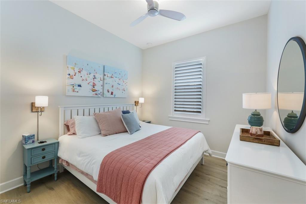 6295 Arriba Avenue Naples, FL 34113 - Photo 18 of 34 a bed room with a bed and a chandelier