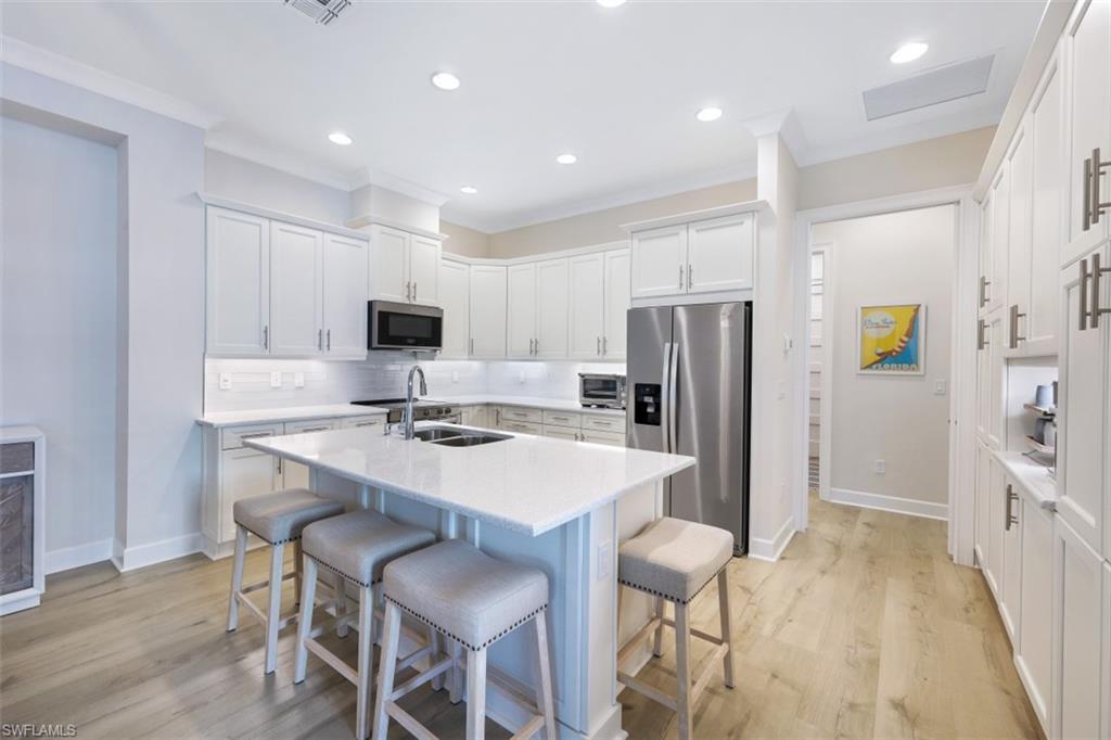 6295 Arriba Avenue Naples, FL 34113 - Photo 3 of 34 a kitchen with refrigerator and chairs