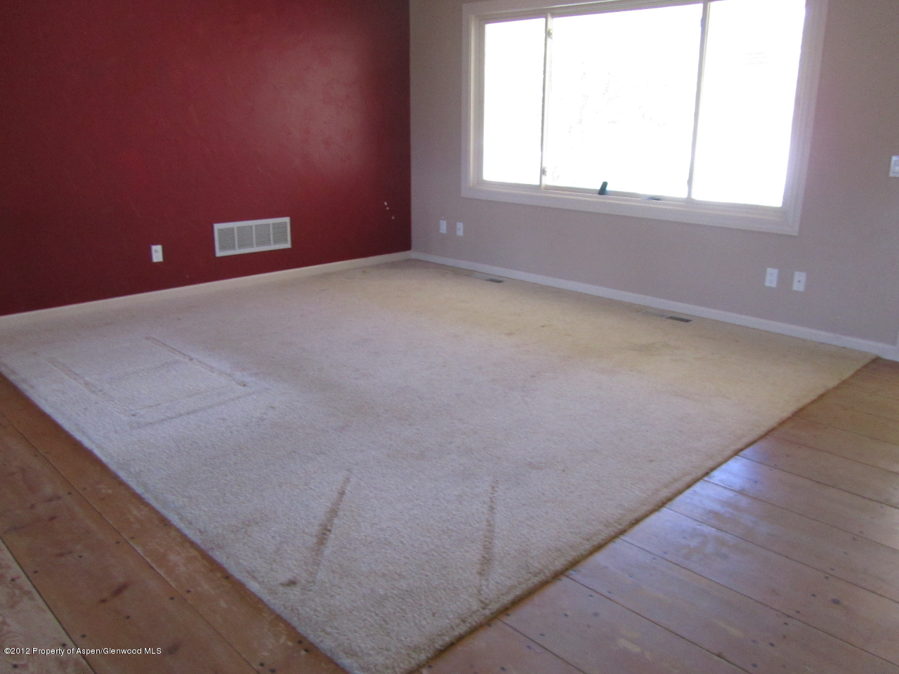 1101 County Road 227 Rifle, CO 81650 - Photo 4 of 9 an empty room with wooden floor and windows