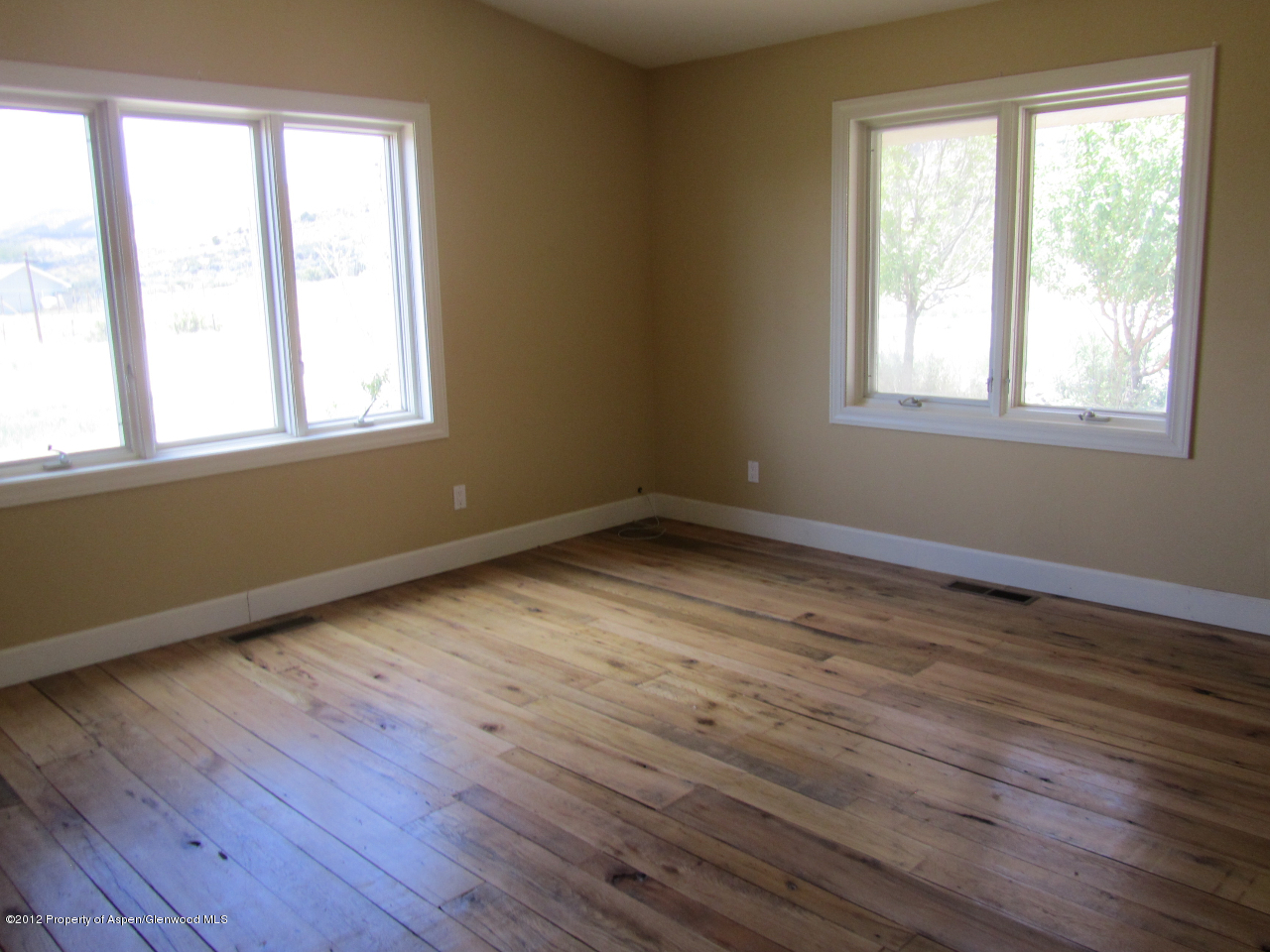 1101 County Road 227 Rifle, CO 81650 - Photo 7 of 9 a view of an empty room with wooden floor and a window