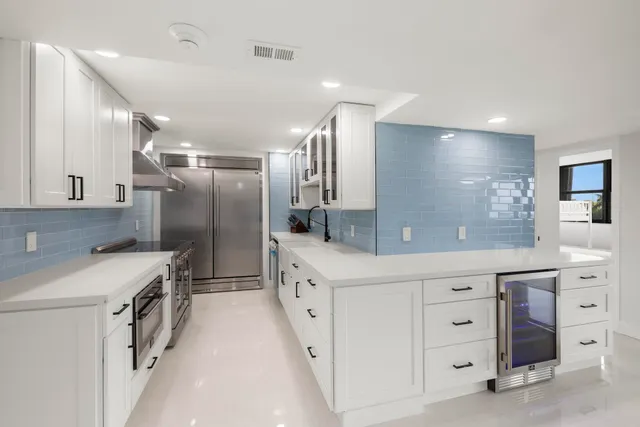 a kitchen with white cabinets and stainless steel appliances