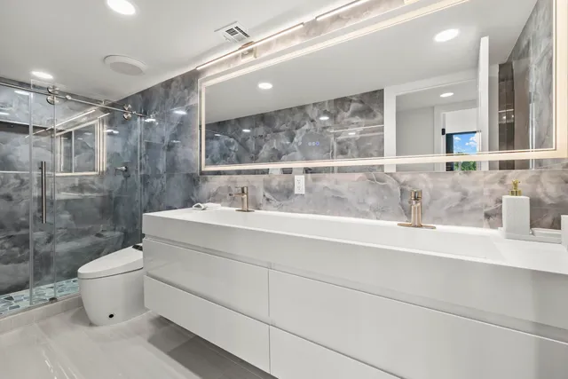 a bathroom with a sink mirror vanity and toilet