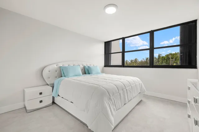 a bedroom with a bed and a large window