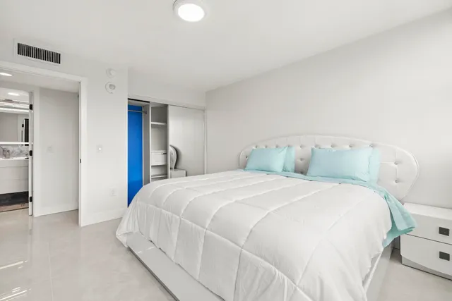 a bedroom with a bed and a refrigerator