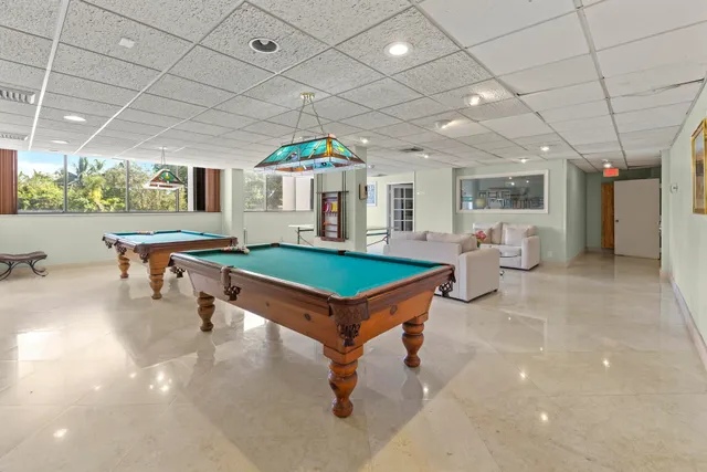a living room with furniture a pool table and a fireplace