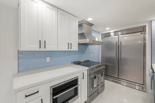 a kitchen with white cabinets and white appliances