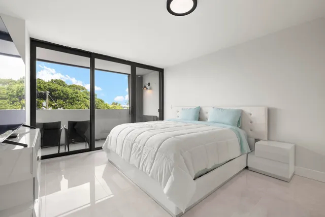 a bedroom with a large bed and a large window