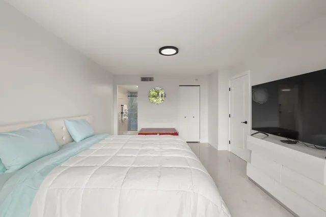 a bedroom with a bed and a flat screen tv