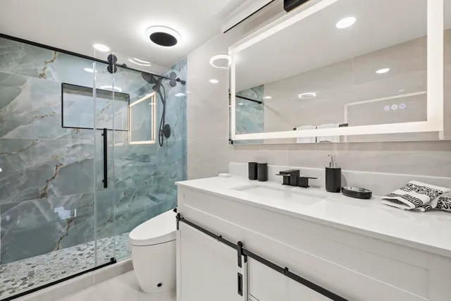 a bathroom with a sink a toilet and shower