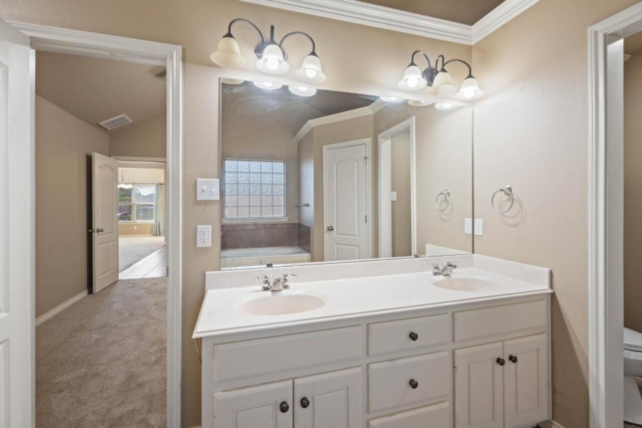 6112 101st Street Lubbock, TX 79424 - Photo 12 of 20 a bathroom with a sink double vanity and a mirror
