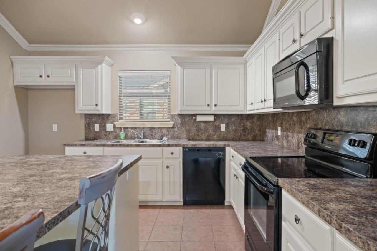 6112 101st Street Lubbock, TX 79424 - Photo 6 of 20 a kitchen with stainless steel appliances granite countertop a sink stove and refrigerator