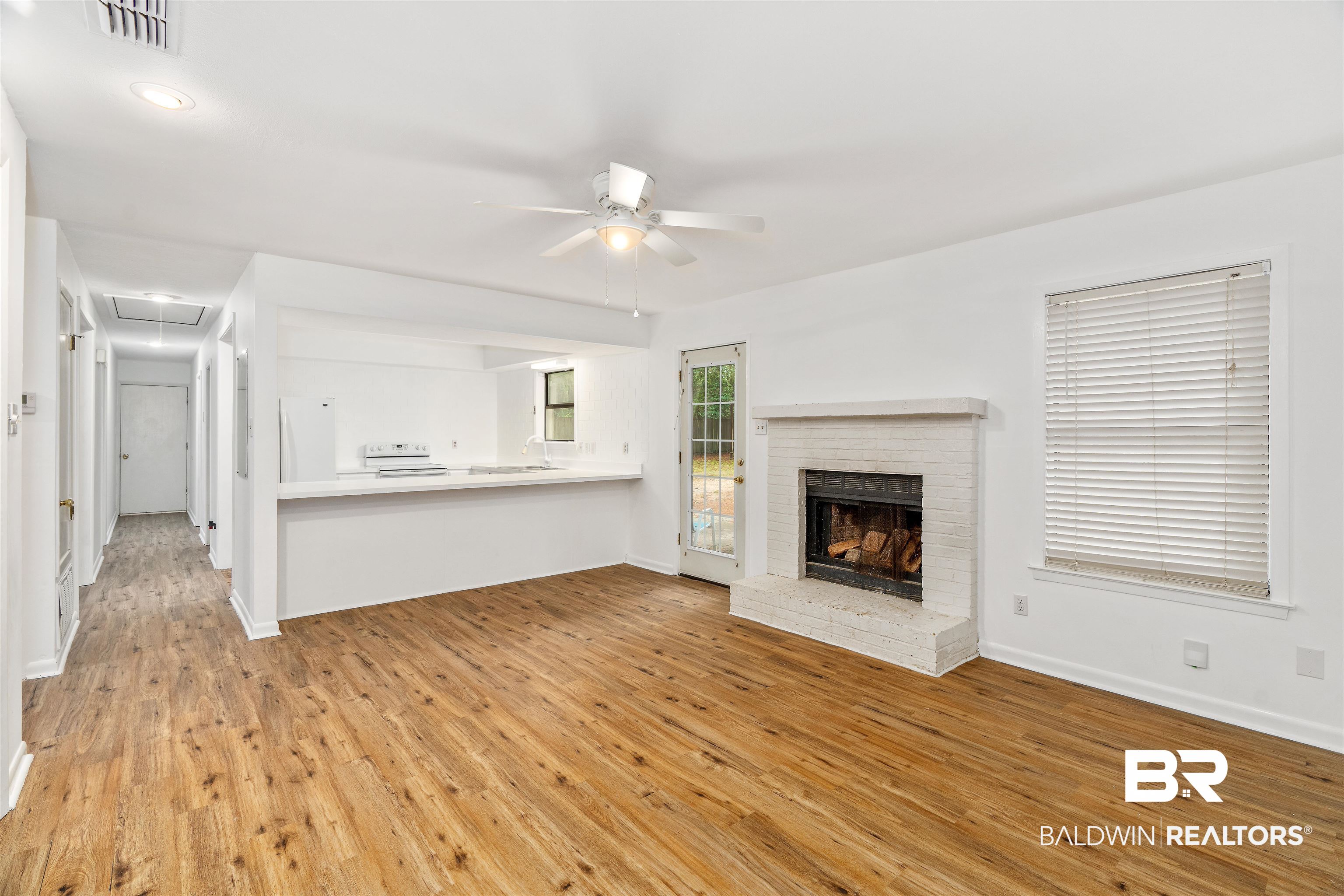159 Montclair Loop Daphne, AL 36526 - Photo 6 of 18 Unfurnished living room featuring attic access, light wood finished floors, a ceiling fan, and a fireplace