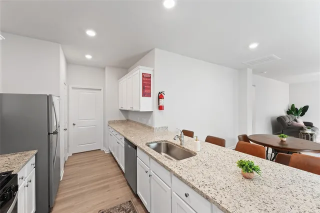 a kitchen with granite countertop a sink stove and refrigerator