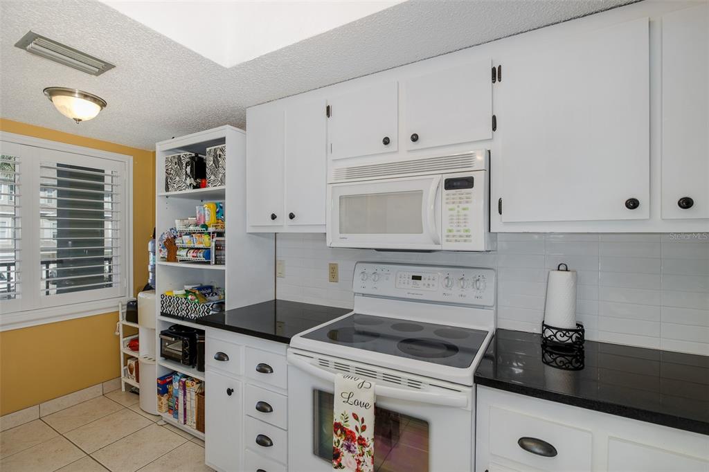 8210 Aquila Street, Unit 213 Port Richey, FL 34668 - Photo 17 of 48 a kitchen with white cabinets and appliances