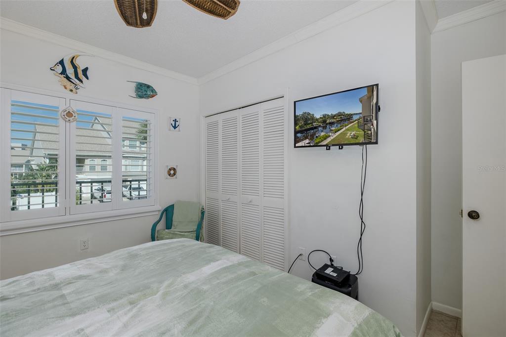 8210 Aquila Street, Unit 213 Port Richey, FL 34668 - Photo 25 of 48 a bedroom with a bed a couch and a window