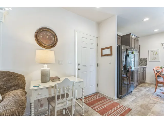 a living room with furniture a clock and a window