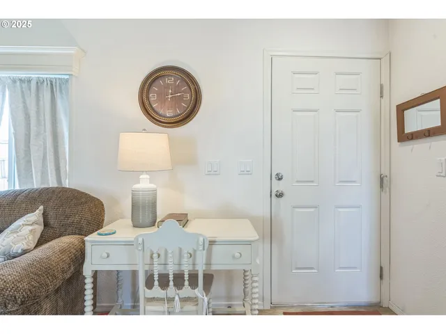 a living room with furniture a clock and a window