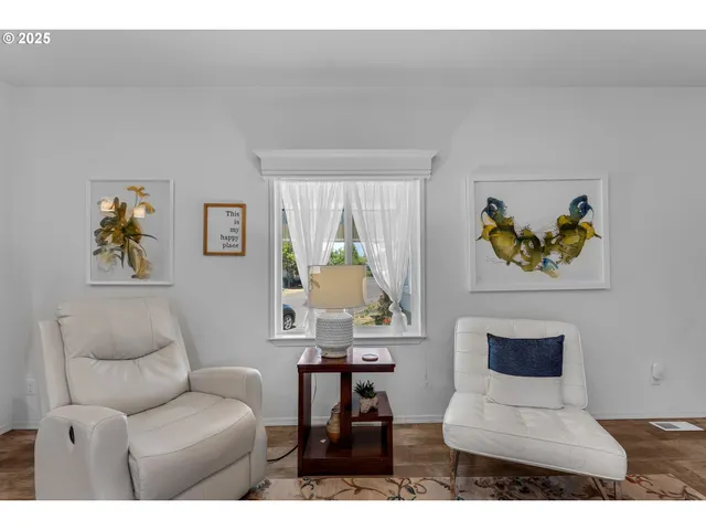 a living room with furniture and a painting on the wall