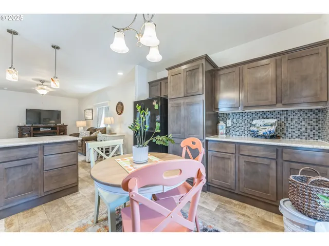 a open kitchen with stainless steel appliances kitchen island granite countertop a sink a stove a dining table and chairs