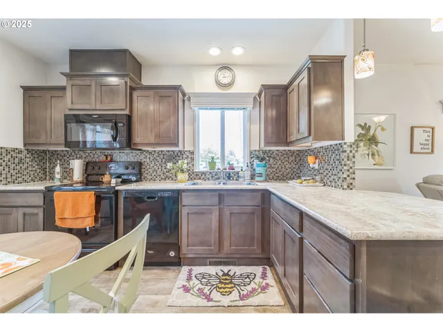 a kitchen with stainless steel appliances granite countertop a sink stove and cabinets