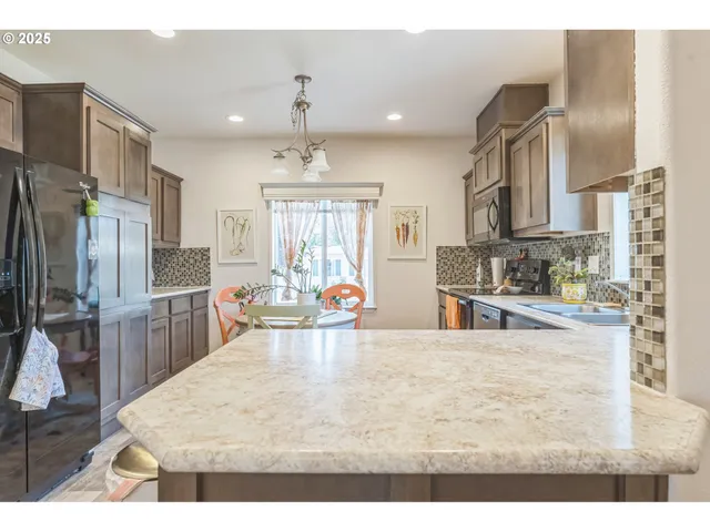 a kitchen with stainless steel appliances kitchen island granite countertop a refrigerator and stove