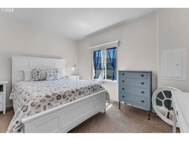 a bedroom with a bed window and a night stand