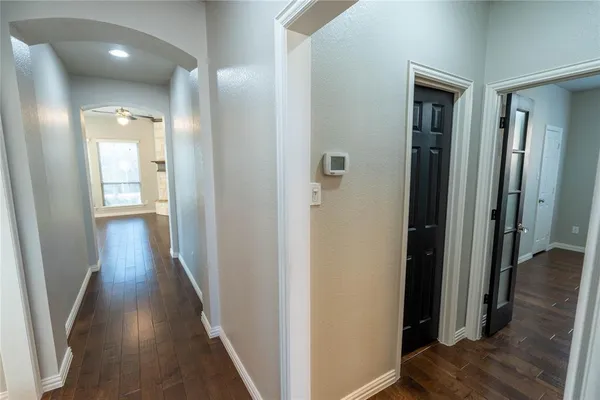 a view of a hallway with wooden floor and closet area