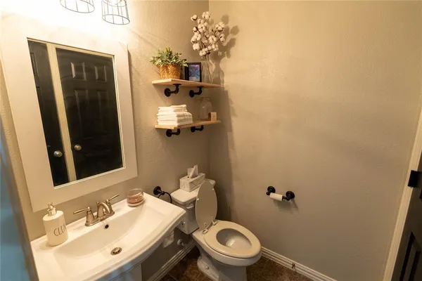 a bathroom with a sink mirror and toilet