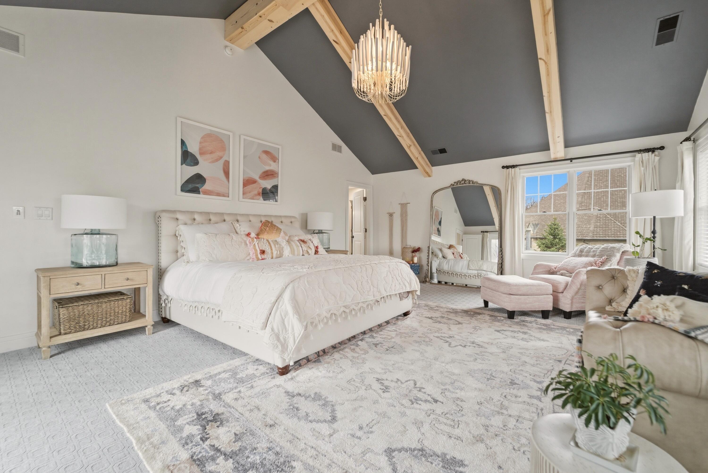 730 Quinlan Court Crown Point, IN 46307 - Photo 41 of 74 a bedroom with a large bed and a chandelier