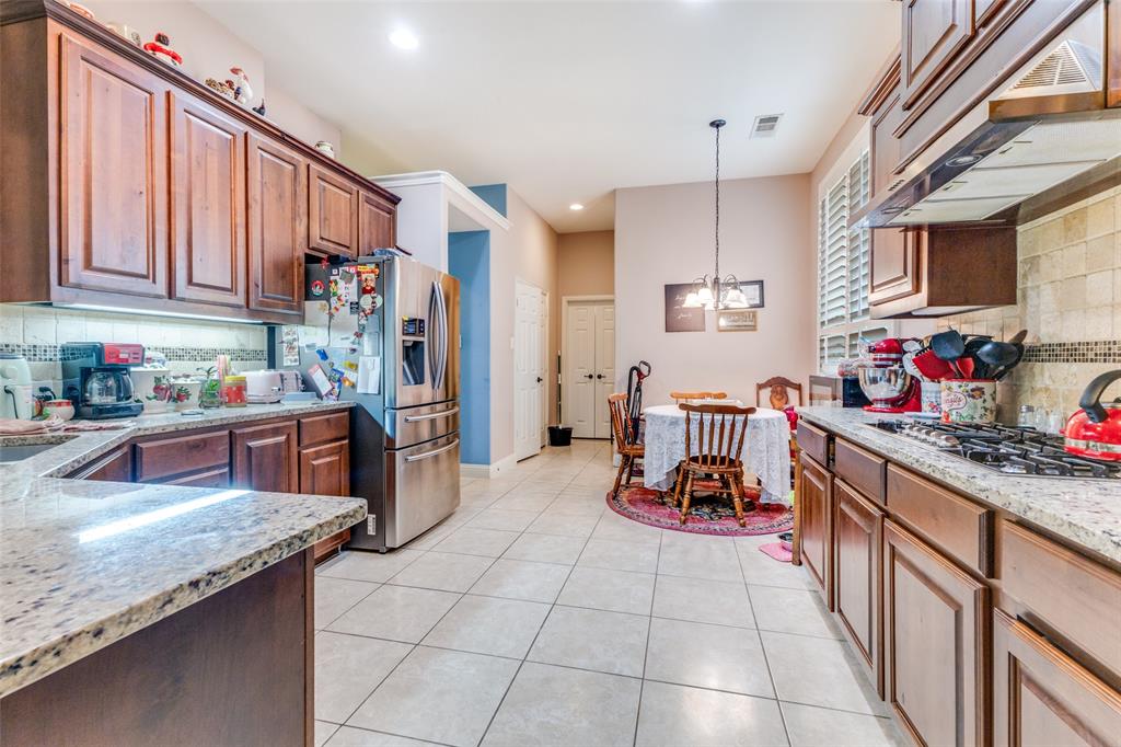 1036 Dunhill Lane Forney, TX 75126 - Photo 12 of 25 a kitchen with stainless steel appliances granite countertop a sink stove and refrigerator