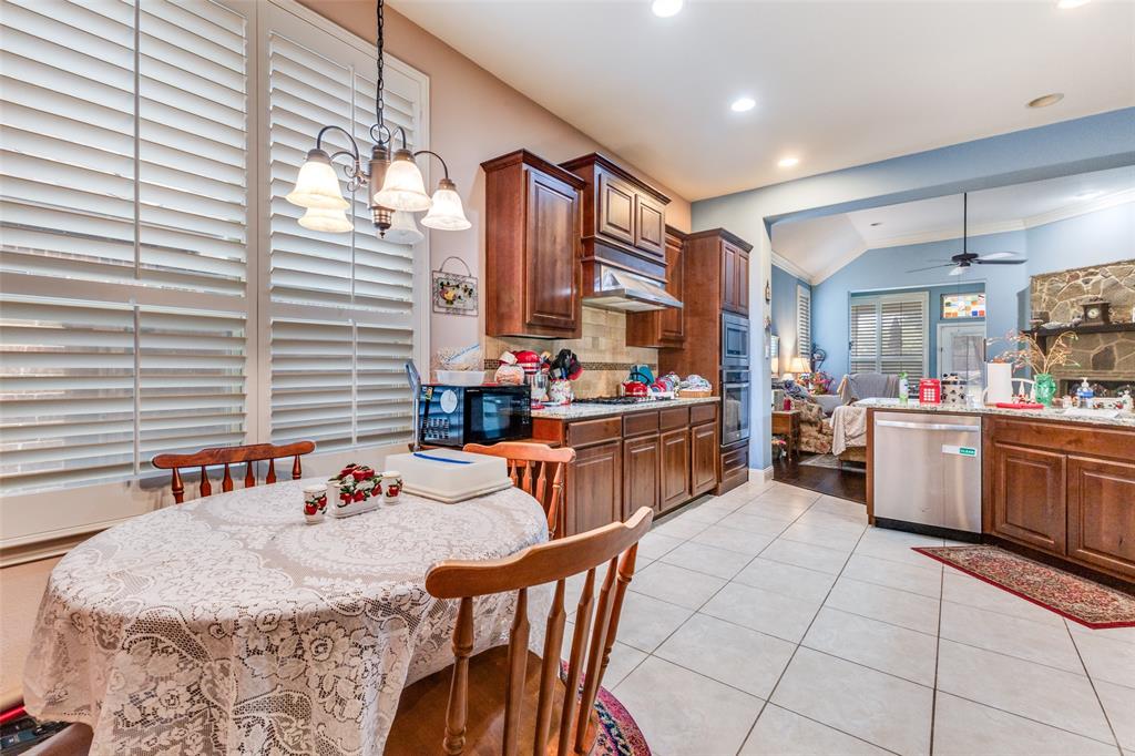 1036 Dunhill Lane Forney, TX 75126 - Photo 10 of 25 a kitchen with stainless steel appliances kitchen island granite countertop a table chairs and a refrigerator