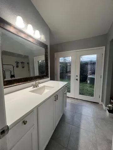 a spacious bathroom with a granite countertop sink and mirror