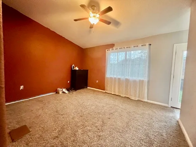 a view of a livingroom with a ceiling fan and window