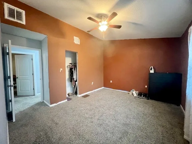 a view of an empty room with a ceiling fan